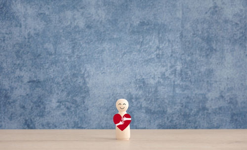Woman standing against blue wall