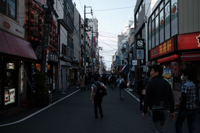 People walking on road along buildings