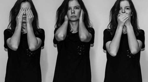 Portrait of young woman standing against wall