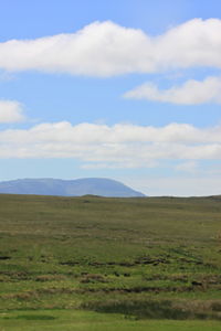 Scenic view of field and mountains against sky