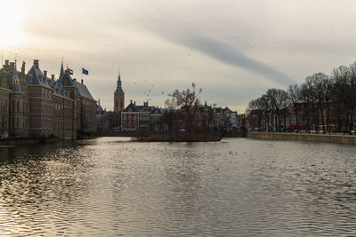 River amidst buildings in city against sky