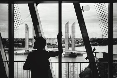 Rear view of man looking through window