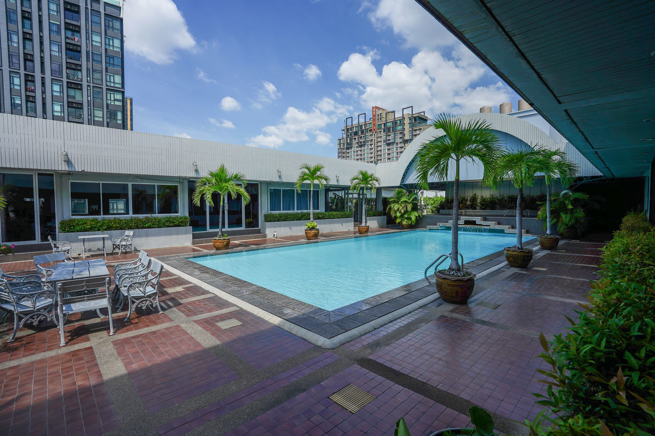 VIEW OF SWIMMING POOL WITH BUILDINGS IN BACKGROUND