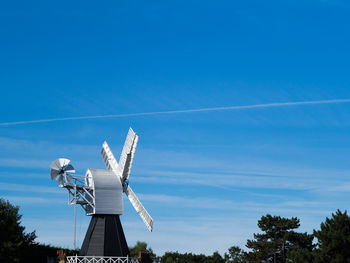 Low angle view of windmill against blue sky