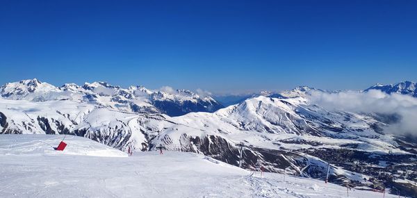 Scenic view of snowcapped mountains against clear blue sky