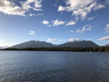 Scenic view of lake by mountains against sky