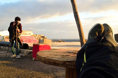 Side view of man with umbrella against sky during sunset