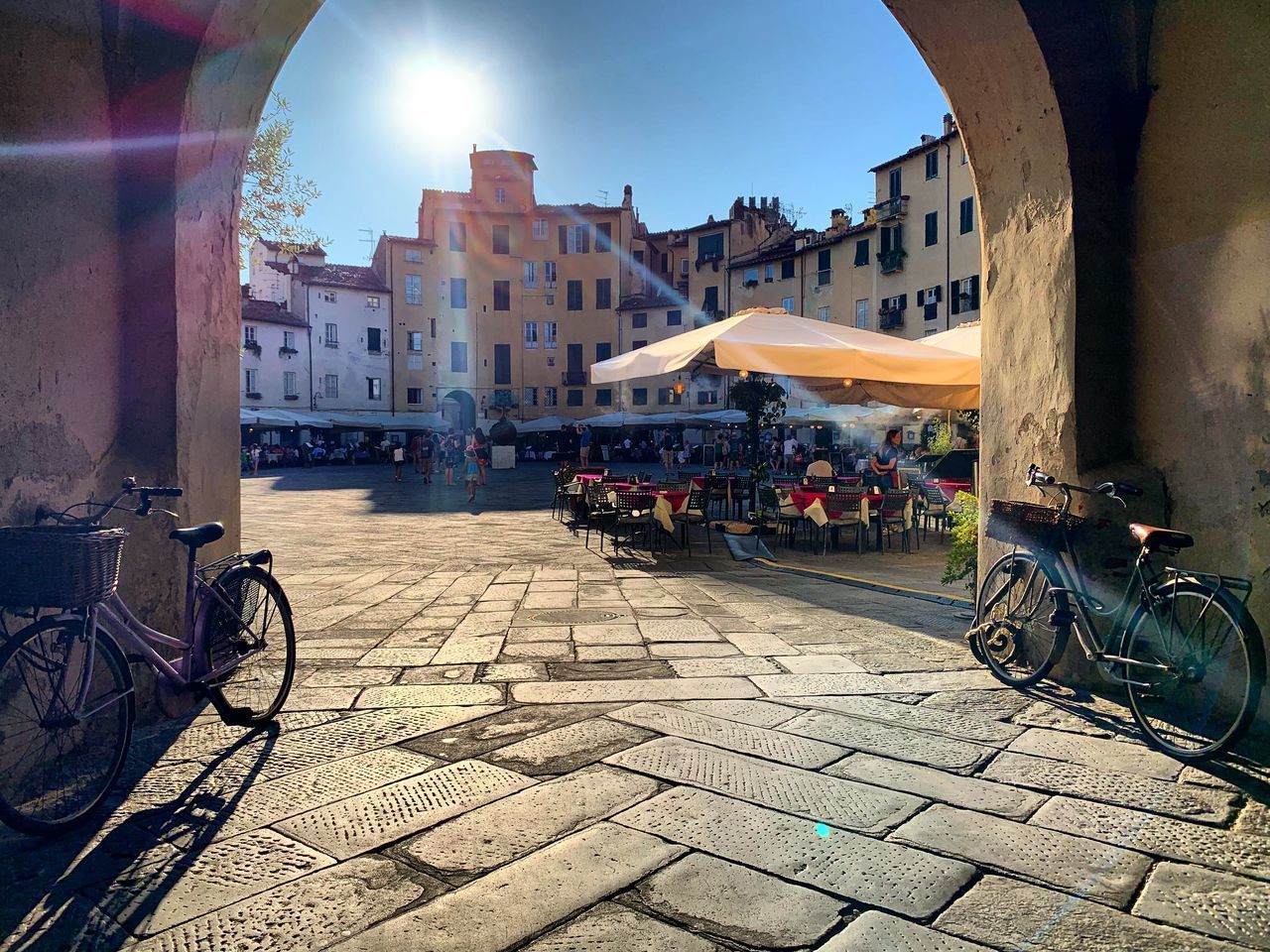 BICYCLES BY STREET IN CITY AGAINST SKY