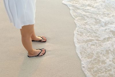 Low section of woman standing on beach