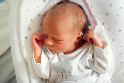 Newborn baby sleeps peacefully. gentle innocent baby lies on light baby cocoon, closeup 