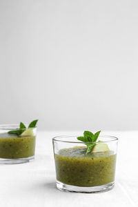 Green fruit on table against white background