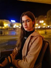 Portrait of young woman sitting outdoors