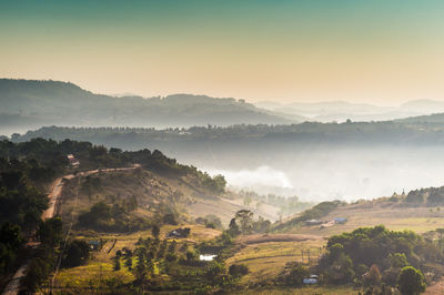 Scenic view of landscape against sky during foggy weather