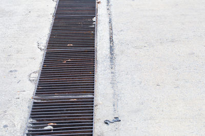 High angle view of metal grate on footpath