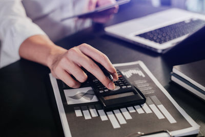 Midsection of man using laptop on table