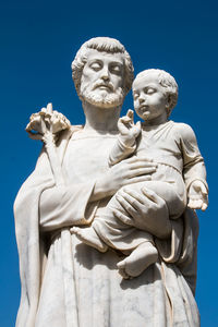 Low angle view of statue against blue sky