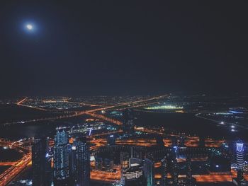 Illuminated cityscape against sky at night