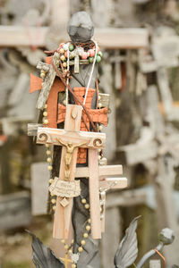 Close-up of cross hanging on wood outside temple