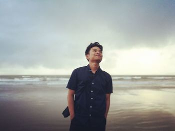 Man standing at beach against sky