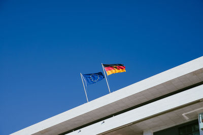 Low angle view of flag flags against clear blue sky