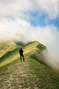 Rear view of man on mountain against sky