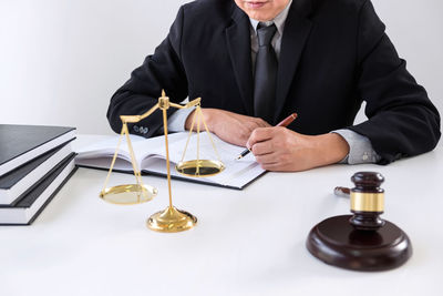 Midsection of a man sitting on table