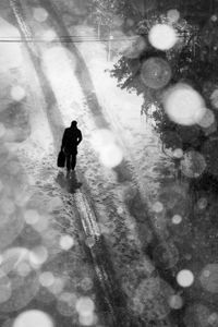 Full length of man walking on snow covered tree