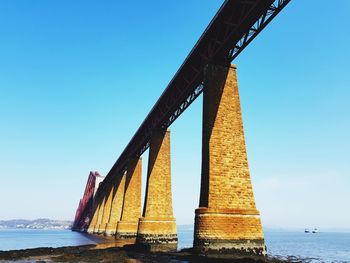 Low angle view of bridge against clear blue sky