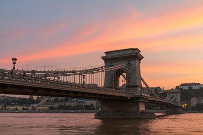 Bridge over river against cloudy sky