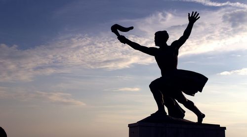 Silhouette of statue against sunset sky