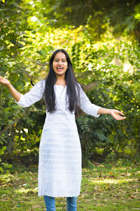 Portrait of smiling young woman standing in sunlight