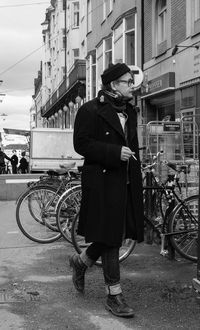 Man standing by bicycle on street in city