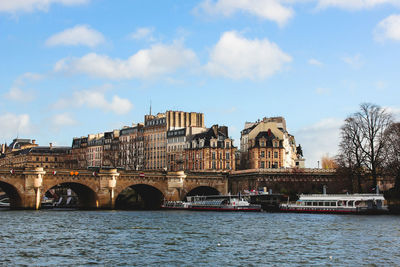 Bridge over river against buildings in city