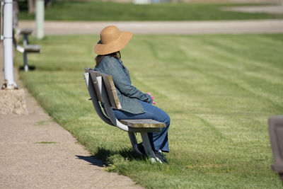 Woman sitting on bench in park