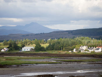 Scenic view of field and mountains against sky