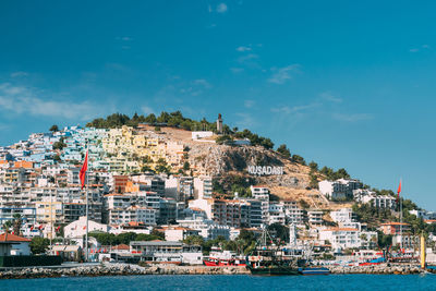 Scenic view of sea by buildings against sky