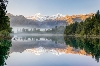 Scenic view of lake and mountains against sky