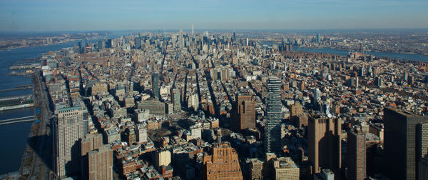 Panoramic shot of cityscape by sea against sky