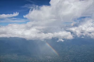 Aerial view of rainbow over landscape against sky