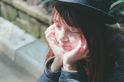 Close-up of young woman wearing hat