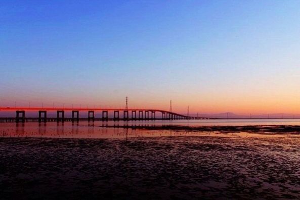 clear sky, copy space, sunset, sea, water, beach, tranquil scene, tranquility, scenics, orange color, beauty in nature, horizon over water, sand, shore, nature, idyllic, dusk, pier, outdoors, bridge - man made structure