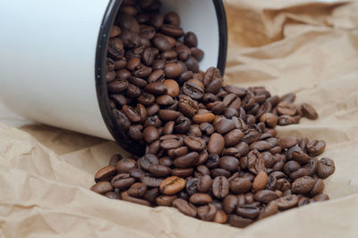 Coffee beans poured out of the white mug