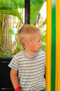 Close-up of cut boys standing in amusement park