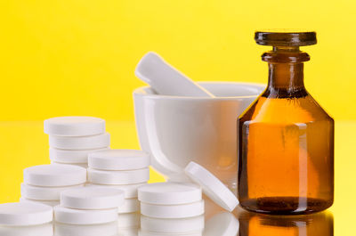 Close-up of bottles against yellow background