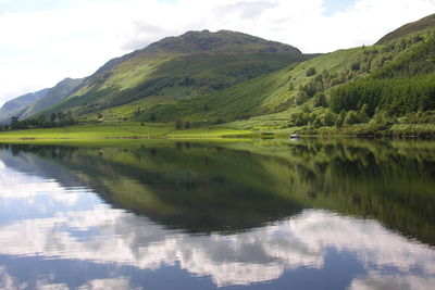 Scenic view of lake and mountains against sky