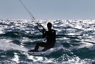 Man surfing in sea against clear sky