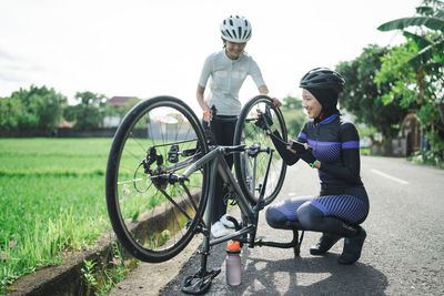 Rear view of man riding bicycle on field