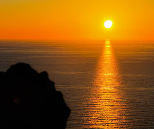 Scenic view of sea against orange sky