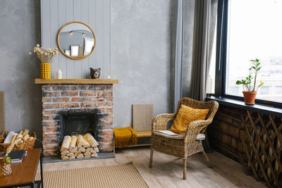 Modern interior with decorative fireplace and rattan chair, scandinavian style.