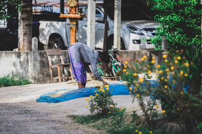 Side view of woman drying food outdoors